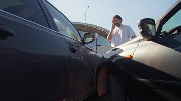 Man is on the phone with his insurance company, explaining to them how he had an accident. Mid shot. Slow motion video