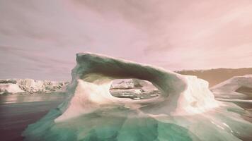 A large iceberg floating in the middle of a body of water video