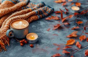 Cozy Autumn Scene With Candles and Knitted Blanket on Gray Background photo