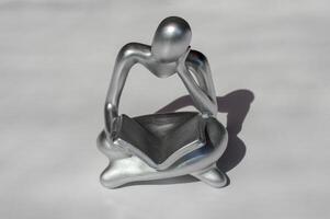 Miniature statue of a person reading photo