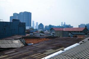 View of dense rooftops in Jakarta with tall buildings in the background photo
