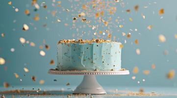 Blue Birthday Cake With Golden Sprinkles Falling on a Light Blue Background photo