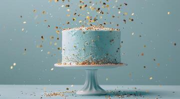 Blue Birthday Cake With Golden Sprinkles Falling on a Light Blue Background photo