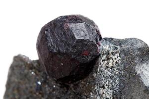 Macro mineral stone garnet in the rock on a white background photo