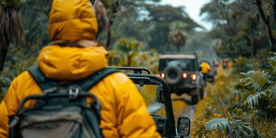 Person in yellow jacket drives jeep on dirt road with backpack photo