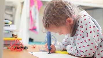 Smart girl drawing with 3D pen on paper at table video
