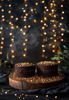 Two Chocolate Cakes With Gold Accents on Rustic Table With Twinkle Lights photo