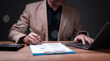 Businessman diligently works through paperwork, ensuring every document is professionally approved and signed, solidifying agreements vital to the success and financial stability of the business. photo