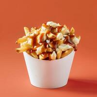 Close up of poutine, a Canadian dish made of french fries, cheese curds, and gravy. photo