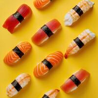 Sushi pattern on a yellow background. Close up of nigiri, salmon, tuna and shrimp sushi. photo