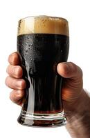 Close up of a man's hand holding a glass with dark beer isolated on a white background photo