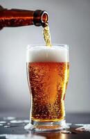 Pouring a glass of golden beer, creating a frothy head, ready to be enjoyed photo