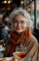 Senior woman smiling with friends, enjoying coffee and croissants at a modern cafe table photo