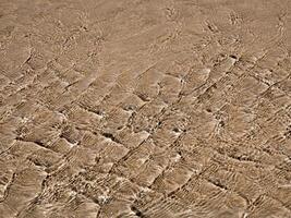 Light reflection on the surface of movement sea on sand beach photo