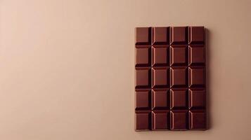 Dark chocolate bar on brown background. A simple yet elegant image of a dark chocolate bar against a brown backdrop, perfect for food blogs and websites. photo