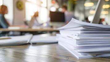 Stack of papers on desk in busy office. A stack of paperwork sits on a desk in a busy office, highlighting the demands and workload of a modern workplace. photo