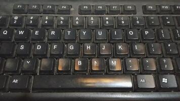 Alphabet letters on a working keyboard shot from under a lamp photo