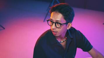 Young man posing in studio with colorful lighting video