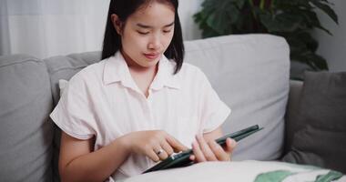 cenas boneca tiro ,despreocupado jovem mulher jogando social meios de comunicação de digital tábua em sofá às casa ,estilo de vida com dispositivo tecnologia video