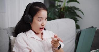 cenas boneca tiro ,despreocupado jovem mulher tendo conectados social conversando com dela amigo de digital tábua em sofá às casa ,estilo de vida com dispositivo tecnologia video