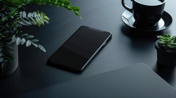 Top view of modern workspace with laptop, smartphone and plant on dark table photo