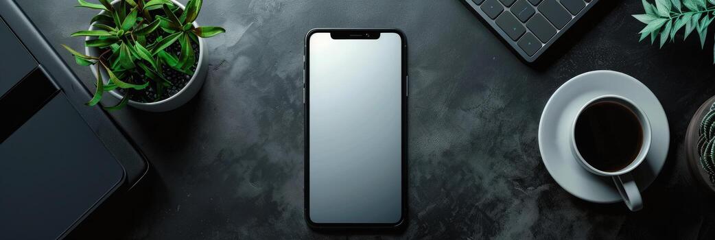 Top view of modern workspace with laptop, smartphone and plant on dark table photo