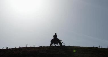 Silhouette of a boy riding a donkey in the mountains on the background of the sunset video