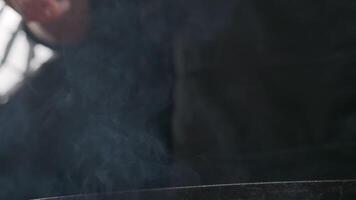 Hand of a chef with a large fork in a steaming grill video