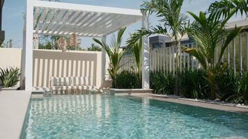 Small swimming pool with canopy and sofa in the backyard of a private villa in Dubai on a sunny day video