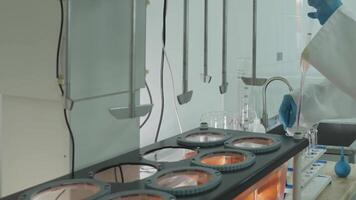 Laboratory technician in protective clothing taking chemical samples from automatic mixer in laboratory video
