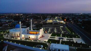 A drone flies around an illuminated mosque at night. Cloudy sky on the background. video