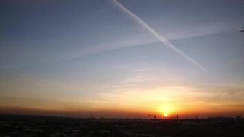 Sunset in the city on a cloudy evening. In the sky, the trail of a flying plane. video
