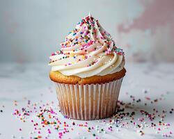 a cupcake with white frosting and sprinkles photo