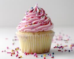 a cupcake with pink frosting and sprinkles photo