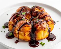 a pastry covered in chocolate sauce on a white plate photo