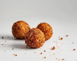 three small balls of food on a white surface photo
