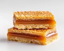 Two pieces of caramel and toffee bars on a white surface photo
