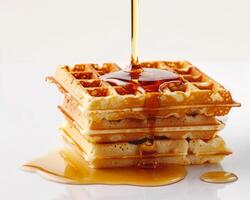 a stack of waffles with syrup being poured on them photo