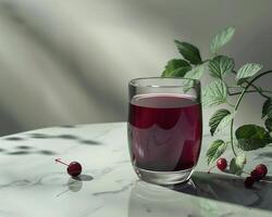 Glass of Juice with Cherries on a Marble Table photo
