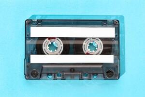 Old tape cassette with blank labels isolated on blue background, Template mock up photo
