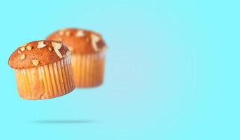 Almond muffins flying isolated on blue background with space for your text. Closeup photo