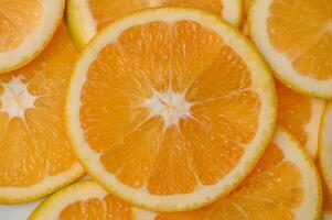 Sliced orange circles, laid on the surface in several layers. Tropical background for design and web photo