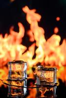 cubes of ice and fire on a water surface on an abstract background photo