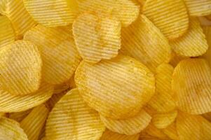 Close-up view of abundant crispy potato chips filling the frame for a textured background 1 photo