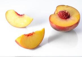 Peach isolated. Whole peach with a slice on white background. Peach fruit with leaf and cut pieces. Full depth of field. photo