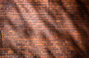 Large full frame background of detailed old red brick wall with shadow with copy space photo