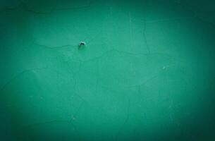 blank green texture surface background with dark corners. green grainy cement wall background with space for text. photo