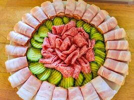 Set of cold cuts for a banquet, meat board with slices of sausage, ham, cucumber photo