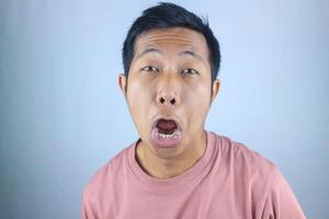 Silly facial expression young asian man looking at camera, isolated on white background photo