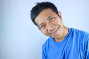 Smiling facial expression young asian man happy looking at camera, isolated on white background photo